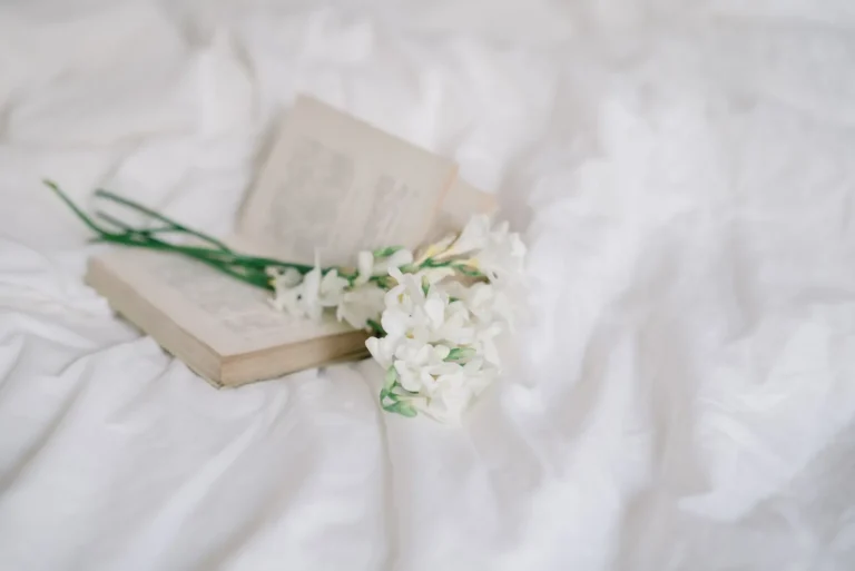 Zijden lakens en bloemen in een zonnige slaapkamer
