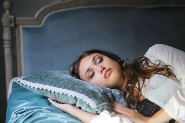 Ontspannen vrouw op zijden lakens in zacht ochtendlicht